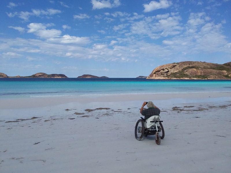 White Trekinetic GTE off road wheelchair on beach overlooking the ocean in Australia