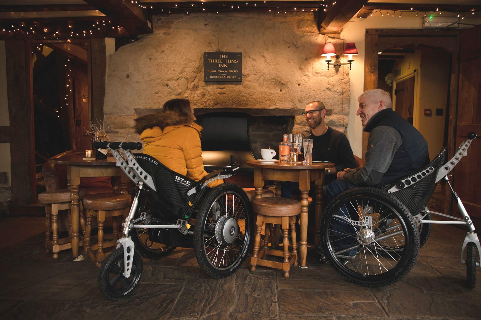 Two Trekinetic wheelchair users meeting a friend in the pub for a drink