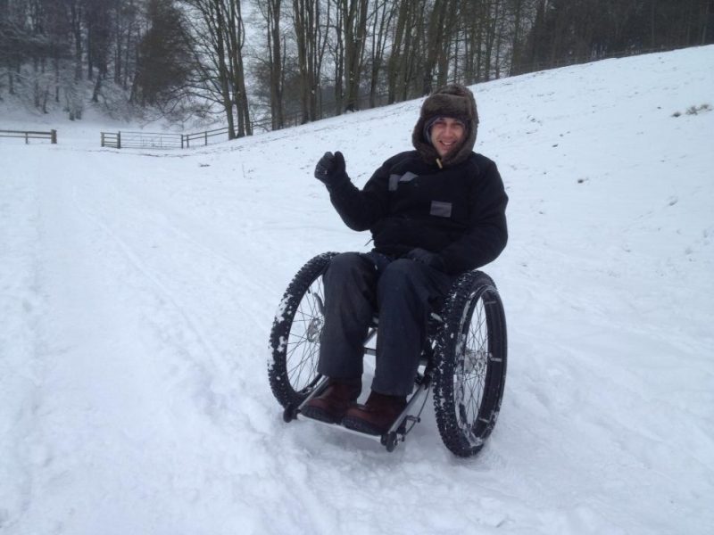 man in Trekinetic K2 manual all terrain wheelchair on snow
