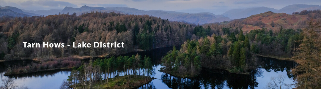A picture of a a beautiful autumn lake and forest. With a heading that reads "Torn Haws Lake District"