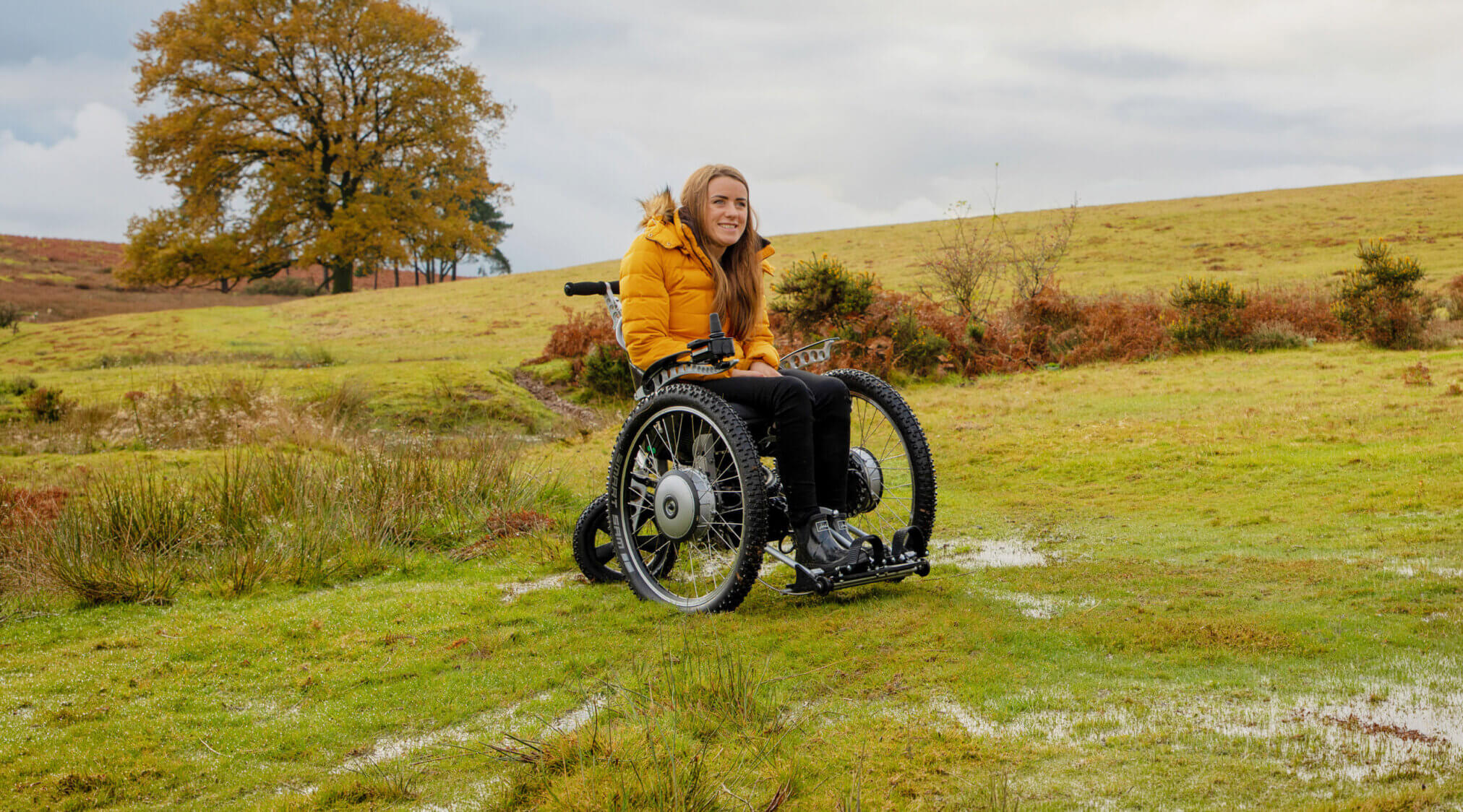 Woman sitting in her GTE on a grassy mound